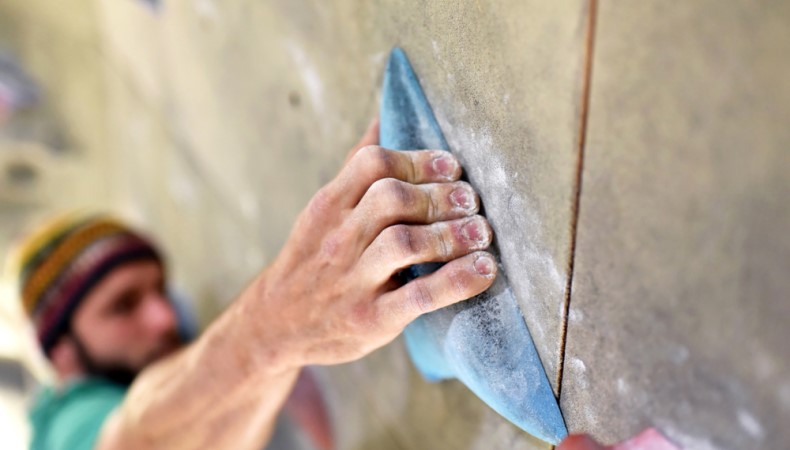 Man gripping a rock climbing wall